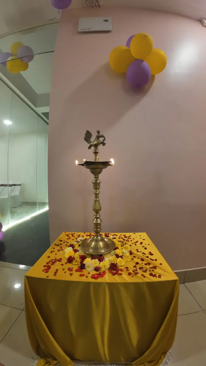 A brass lamp lit and decorated with flower petals at the opening of Ekreeti Creatives